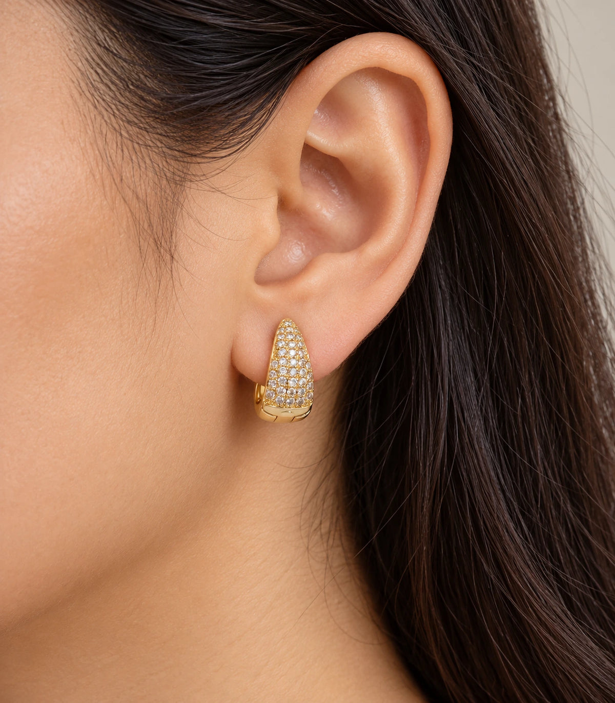 JIMIKI Gold Tone tapered pave huggie hoop earrings, worn on the ear #color_gold-tone
