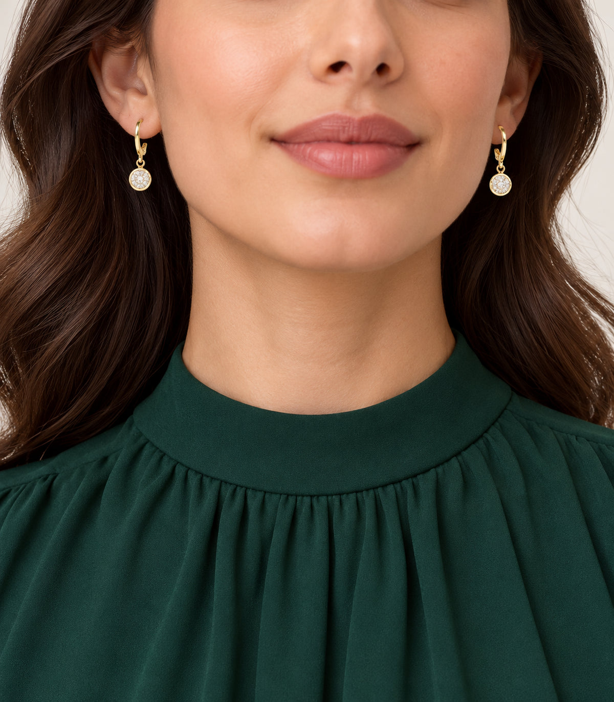 Gold-tone clear crystal hoop earrings from the three-pair set in editorial model view
