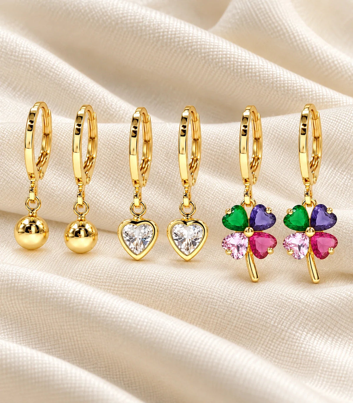 Gold-tone three-pair ball, heart crystal and multicolour clover hoop set — editorial-flatlay #Color_Gold Tone