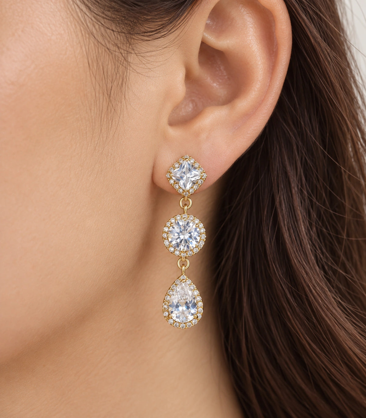 JIMIKI Gold-Tone Three-Stone Halo Drop Earrings in Gold / Clear, close-up detail