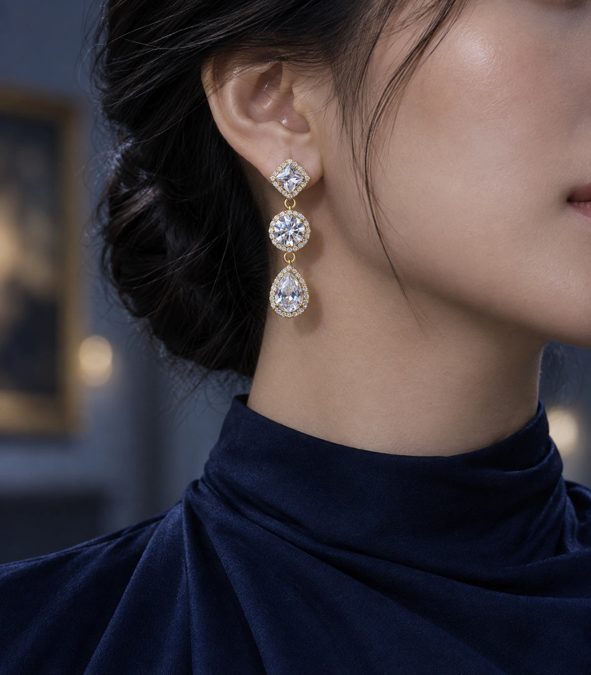 JIMIKI Gold-Tone Three-Stone Halo Drop Earrings in Gold / Clear, editorial model view