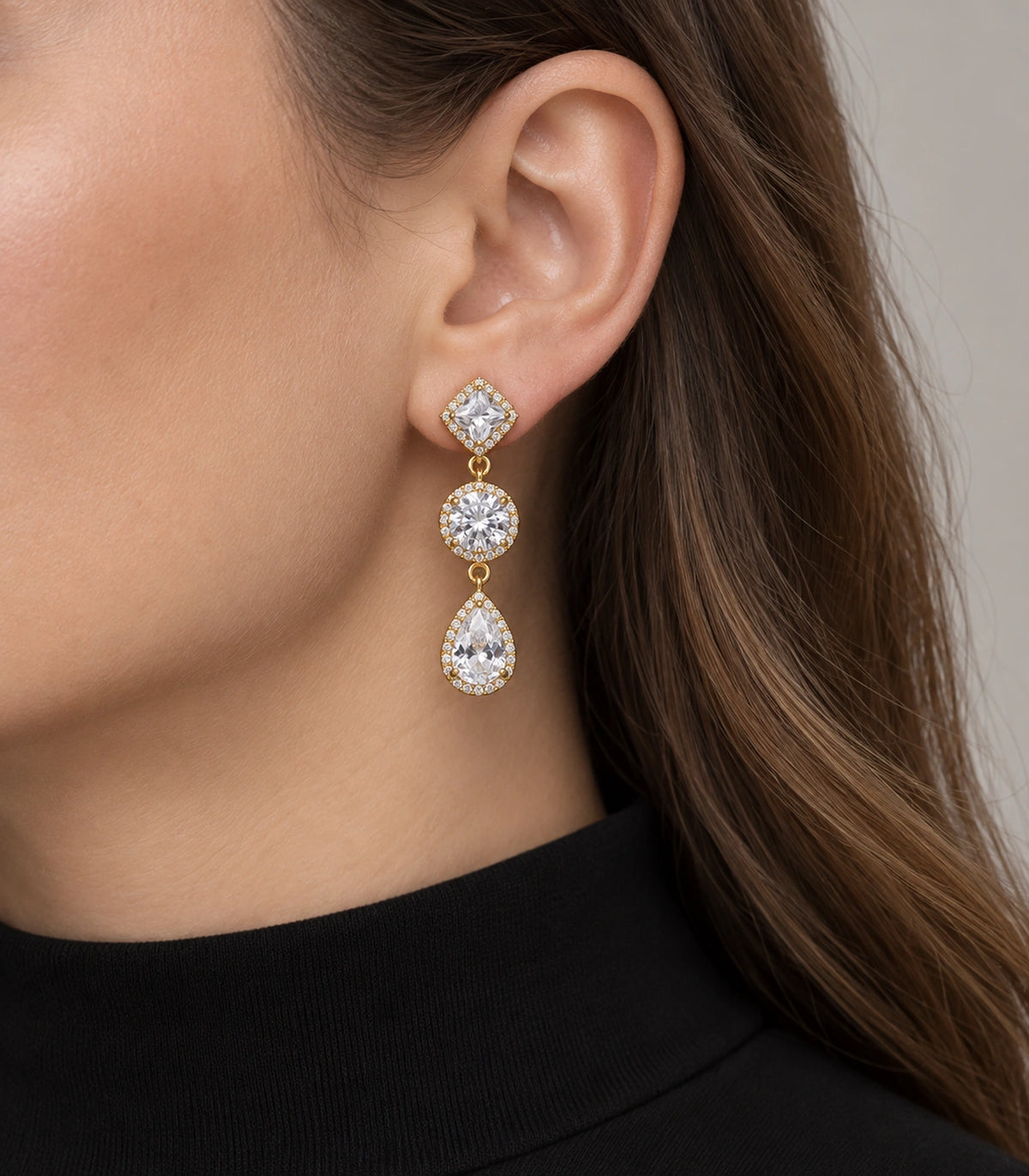 JIMIKI Gold-Tone Three-Stone Halo Drop Earrings in Gold / Clear, model wearing view