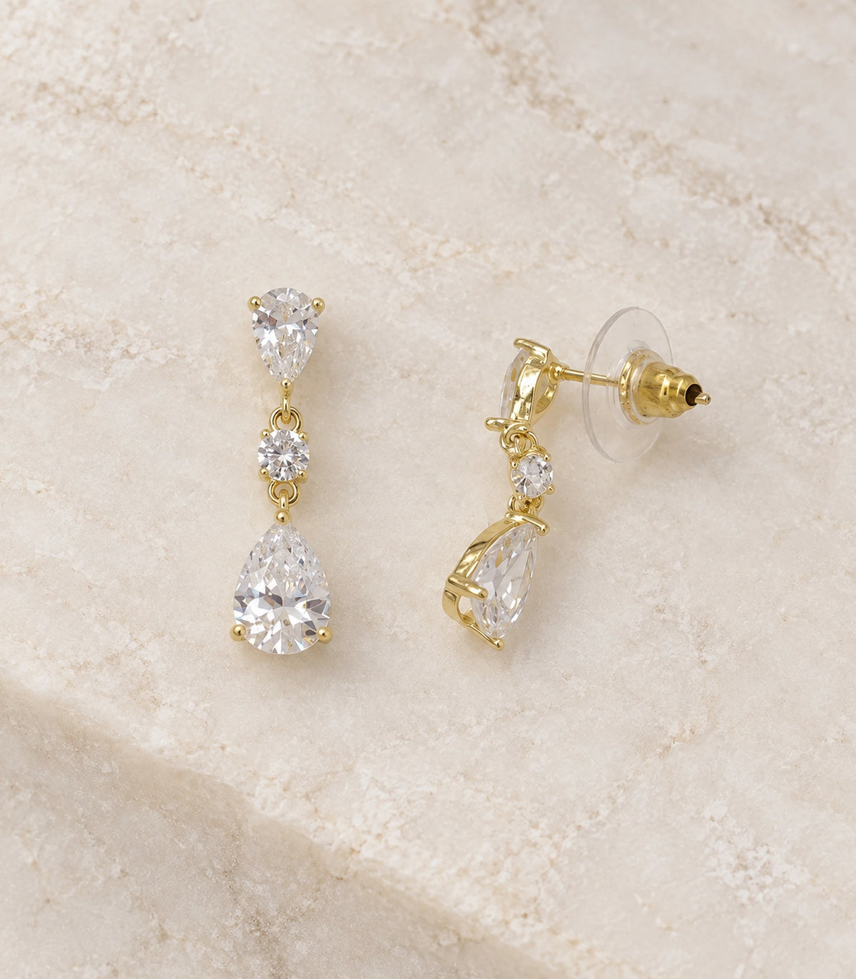 JIMIKI Gold Tone Three Stone Pear Drop Earring Pair in Gold-tone, editorial flat lay