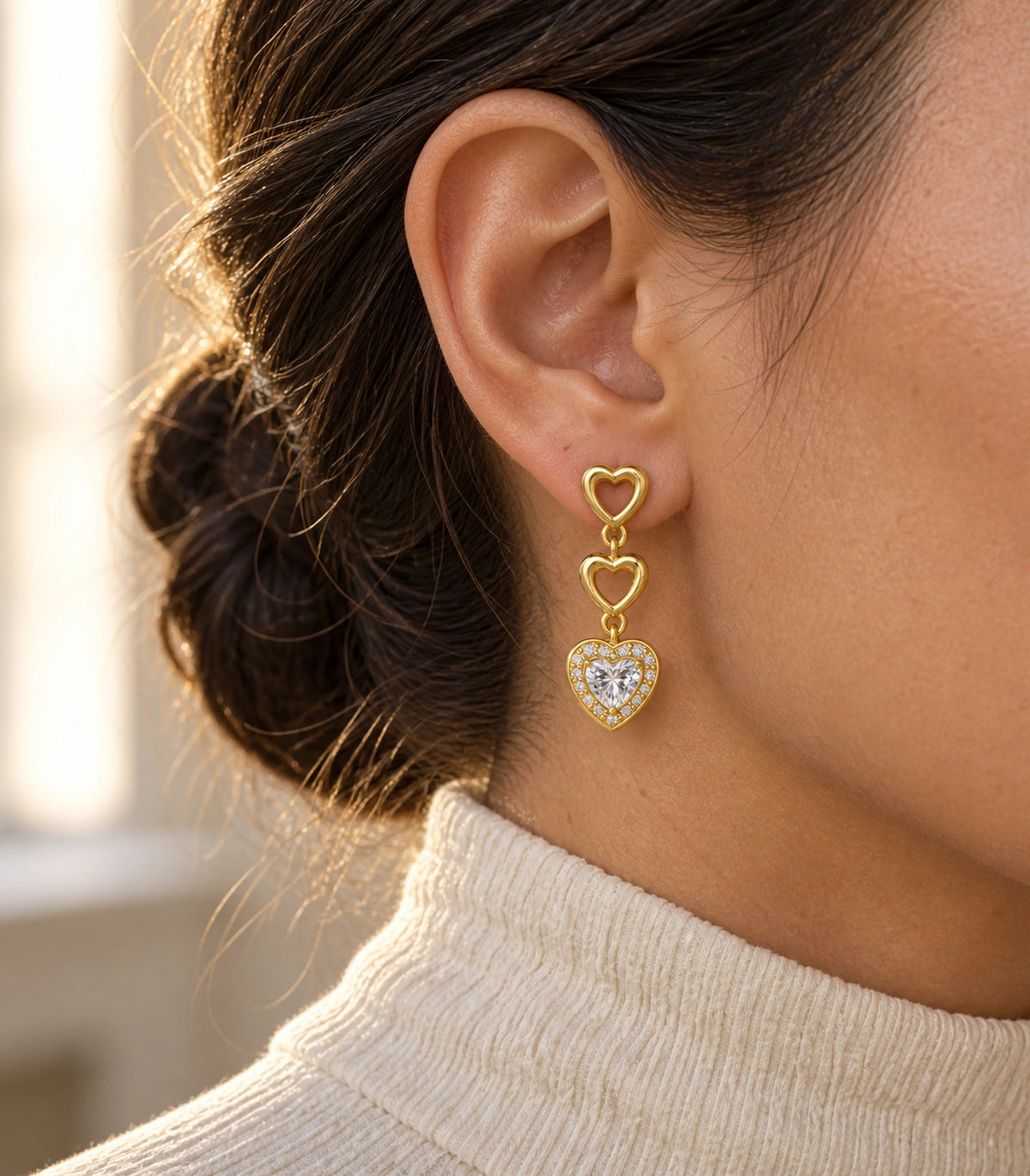 JIMIKI Triple Heart Crystal Drop Earring Pair in Gold tone / clear, editorial model view #color_gold tone / clear