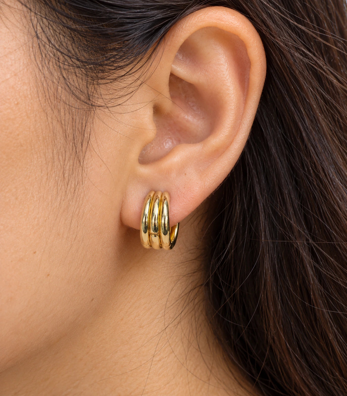 JIMIKI Triple-Ridge Huggie Hoop Earrings in Gold Tone - closeup #color_gold-tone