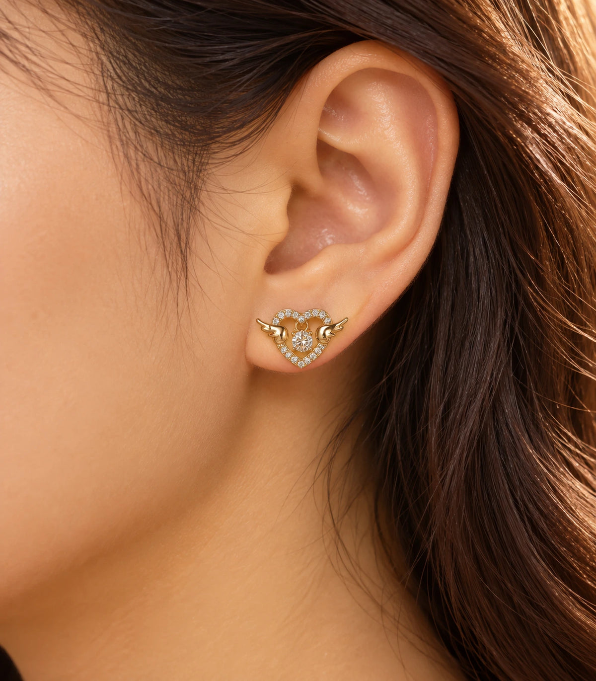 JIMIKI Winged Heart Crystal Stud Earrings in Gold Tone — editorial worn styling #color_gold-tone