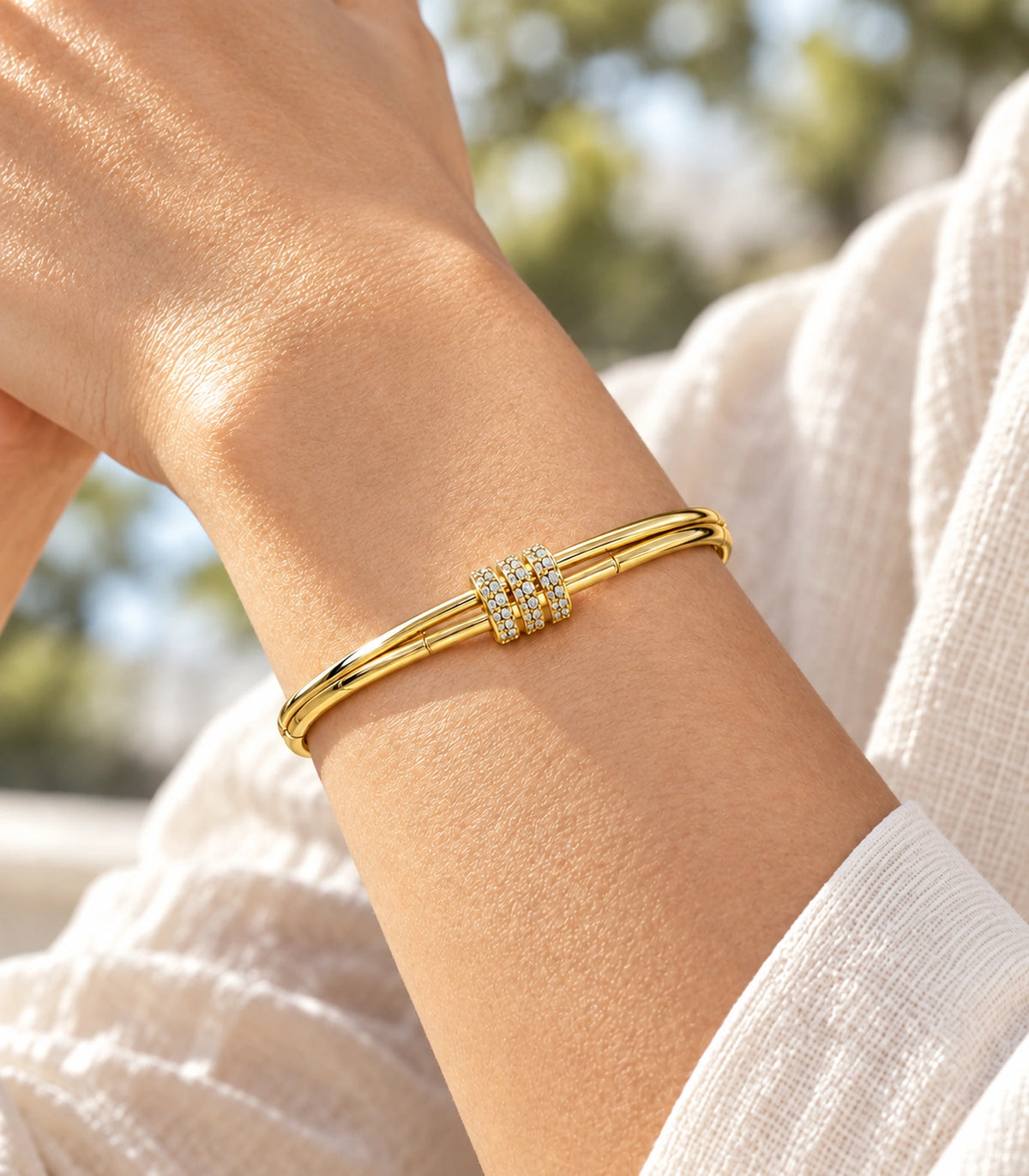 JIMIKI Gold-Tone Triple Pavé Band Double-Rail Bangle — close-up of the bangle worn on the wrist #color_gold-tone / clear