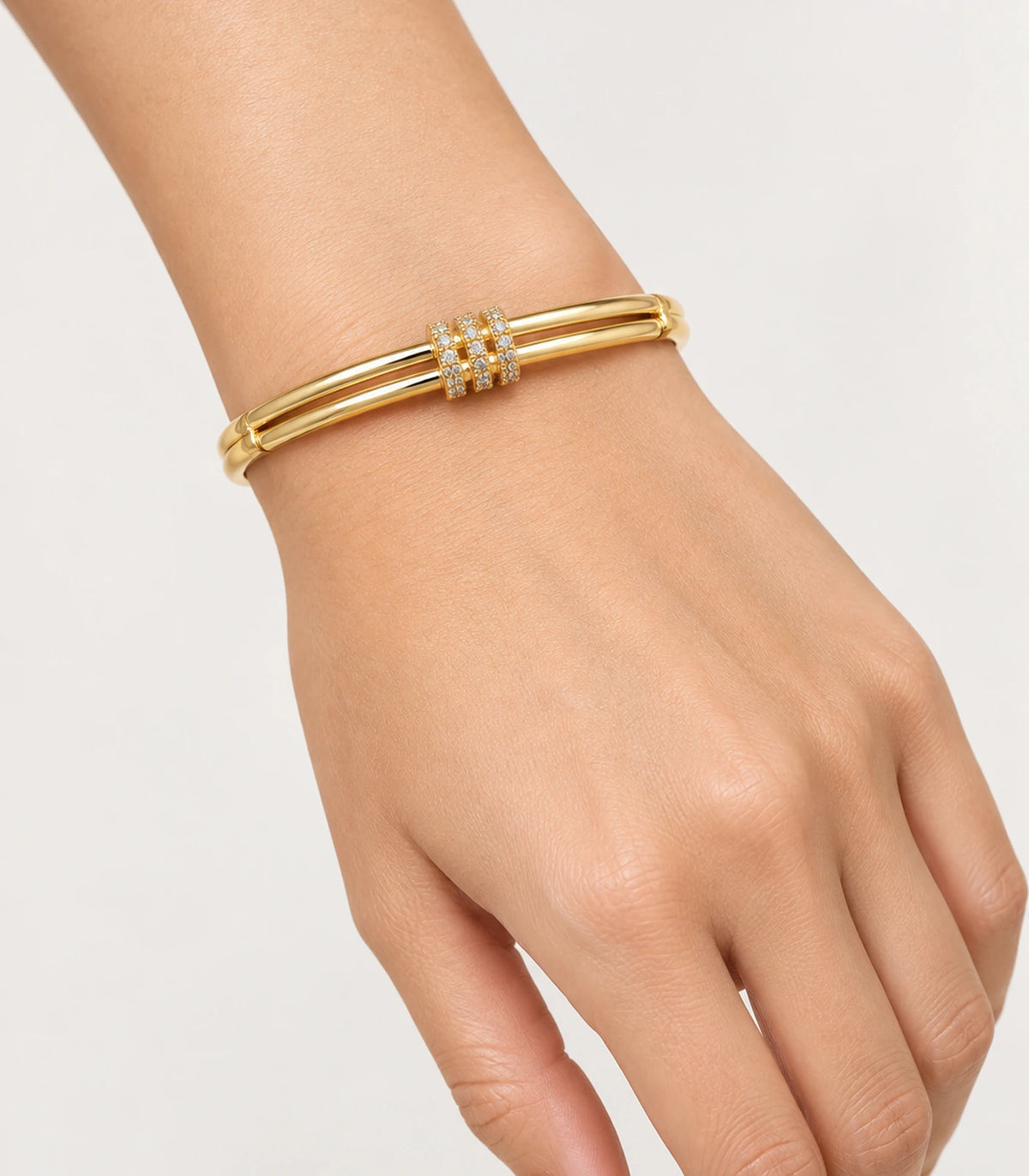 JIMIKI Gold-Tone Triple Pavé Band Double-Rail Bangle — worn on the wrist #color_gold-tone / clear