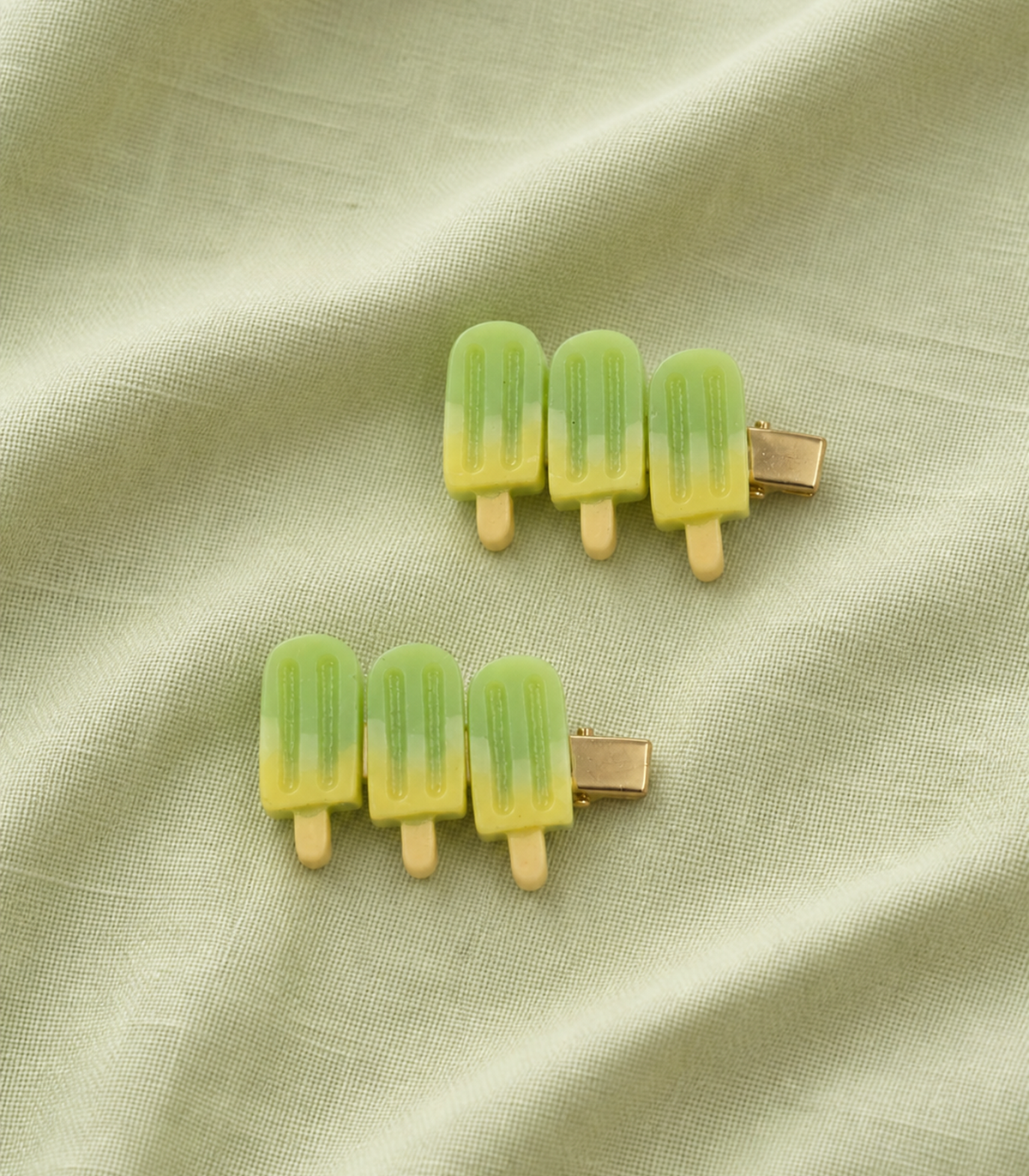 Green Popsicle Trio Clip Pair in an editorial flat lay