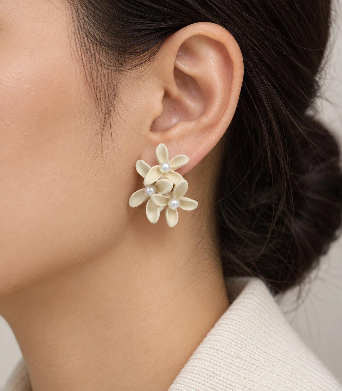 JIMIKI Ivory cascading floral cluster stud earrings, worn on the ear with the floral cluster visible #color_ivory