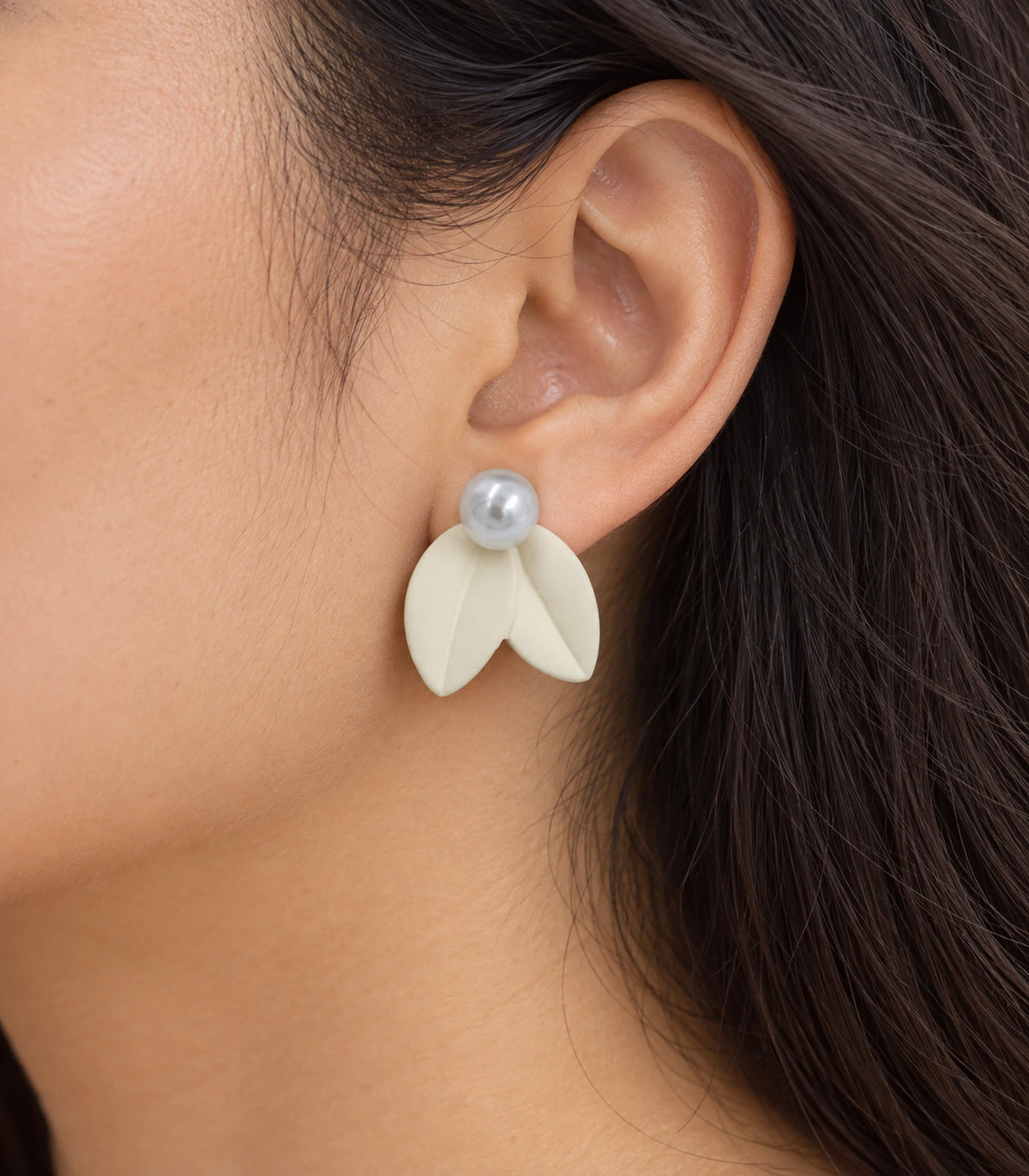 JIMIKI Double Leaf Pearl Stud Earrings in Ivory — close-up of the earring worn on the ear #color_ivory