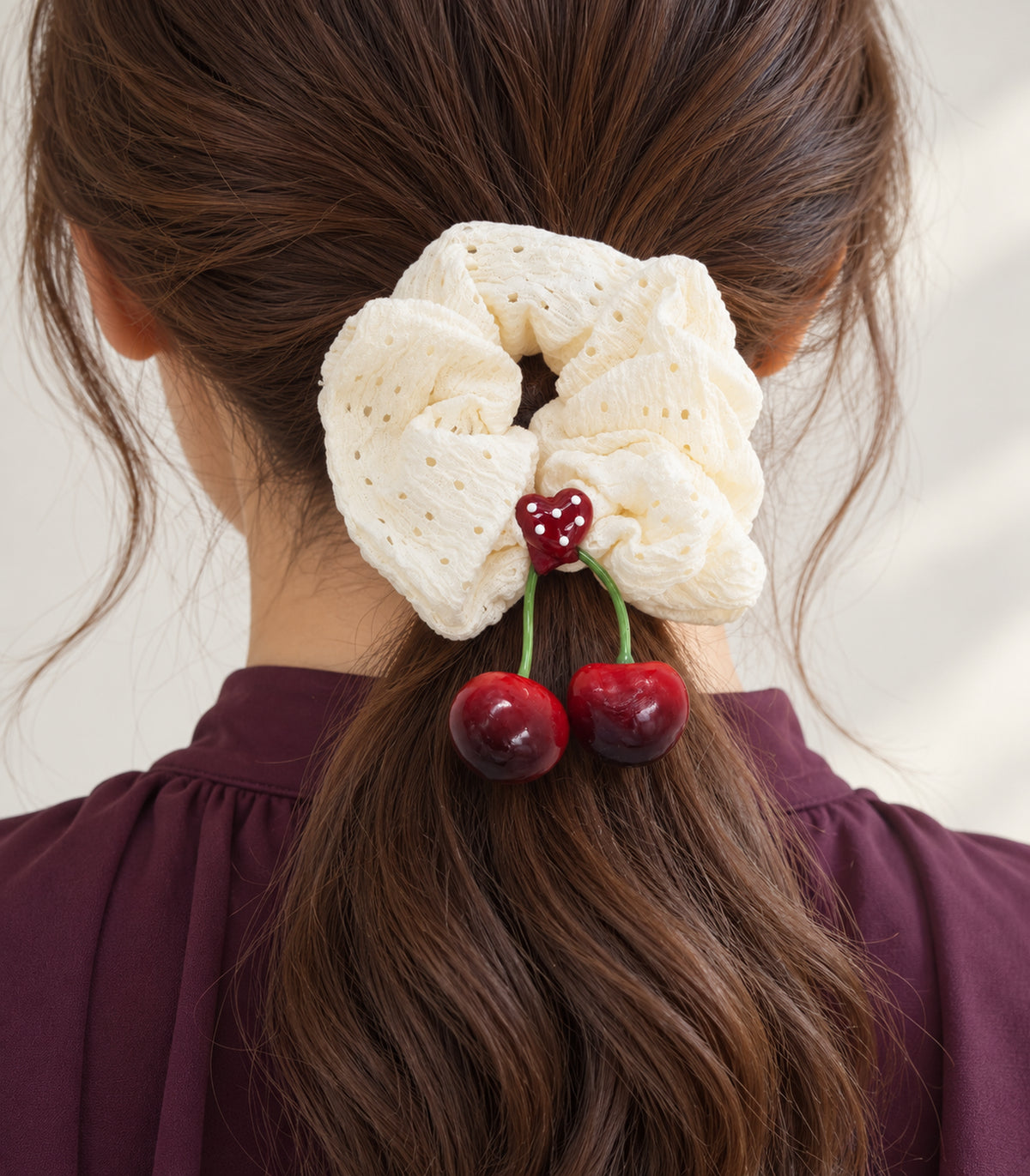 Ivory eyelet cherry scrunchie with dotted heart centre — closeup view