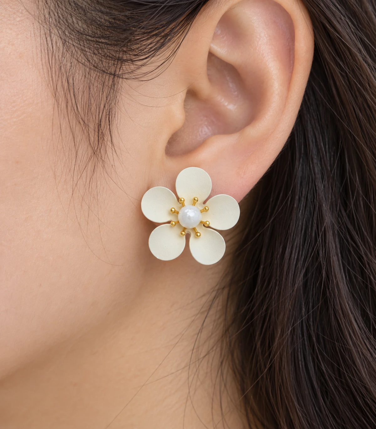 JIMIKI ivory five-petal flower stud earrings with pearl-effect centre, close-up of five petals and eight gold-tone spokes #color_ivory