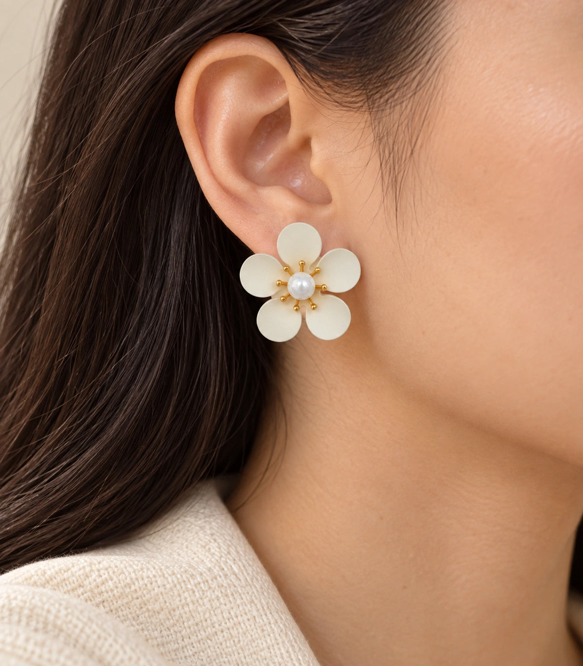 JIMIKI ivory five-petal flower stud earrings with pearl-effect centre, stud worn with cream knit clothing #color_ivory