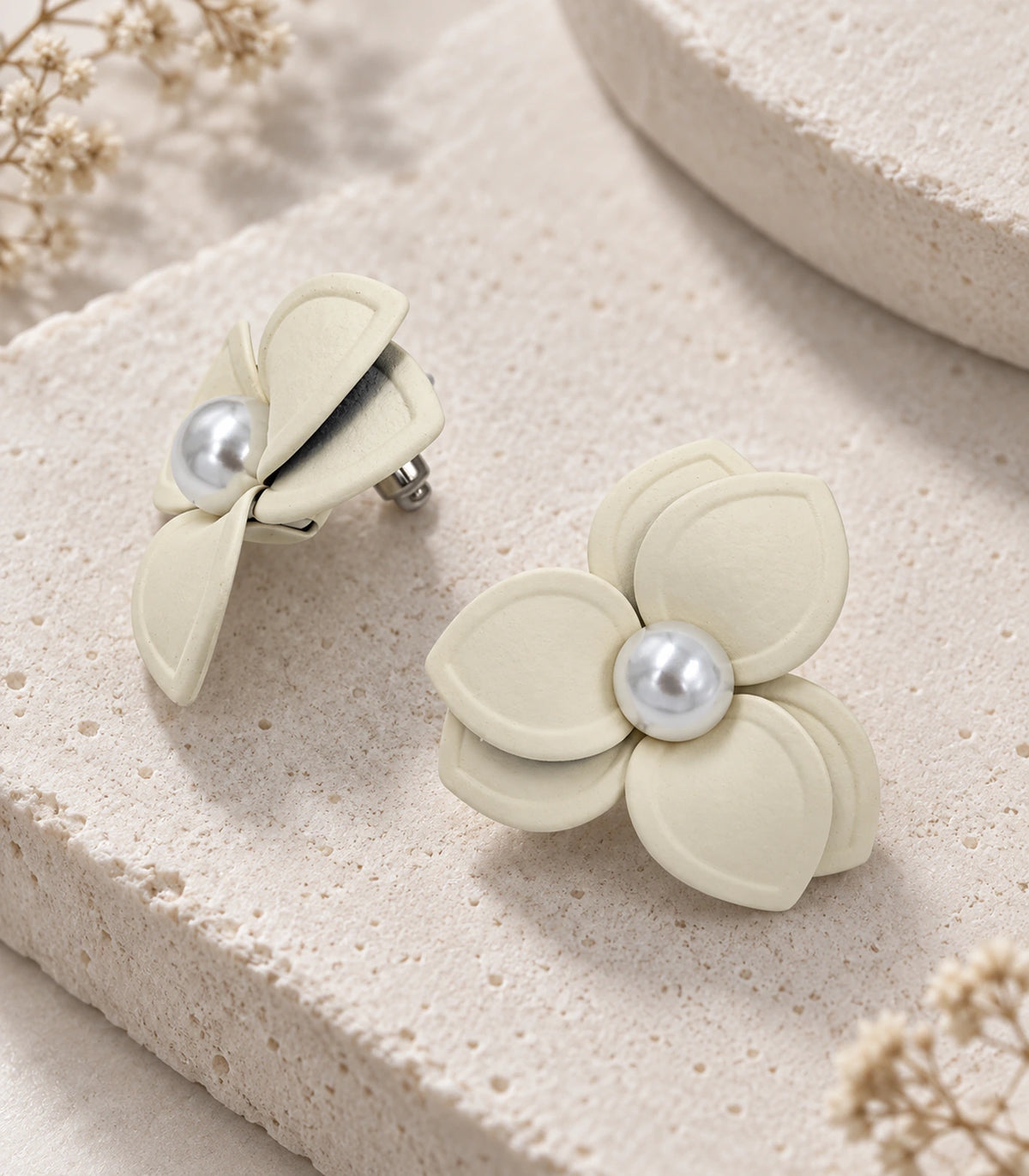 JIMIKI Ivory Triple Petal Pearl Flower Stud Earrings - complete matching pair in styled flat lay #color_ivory