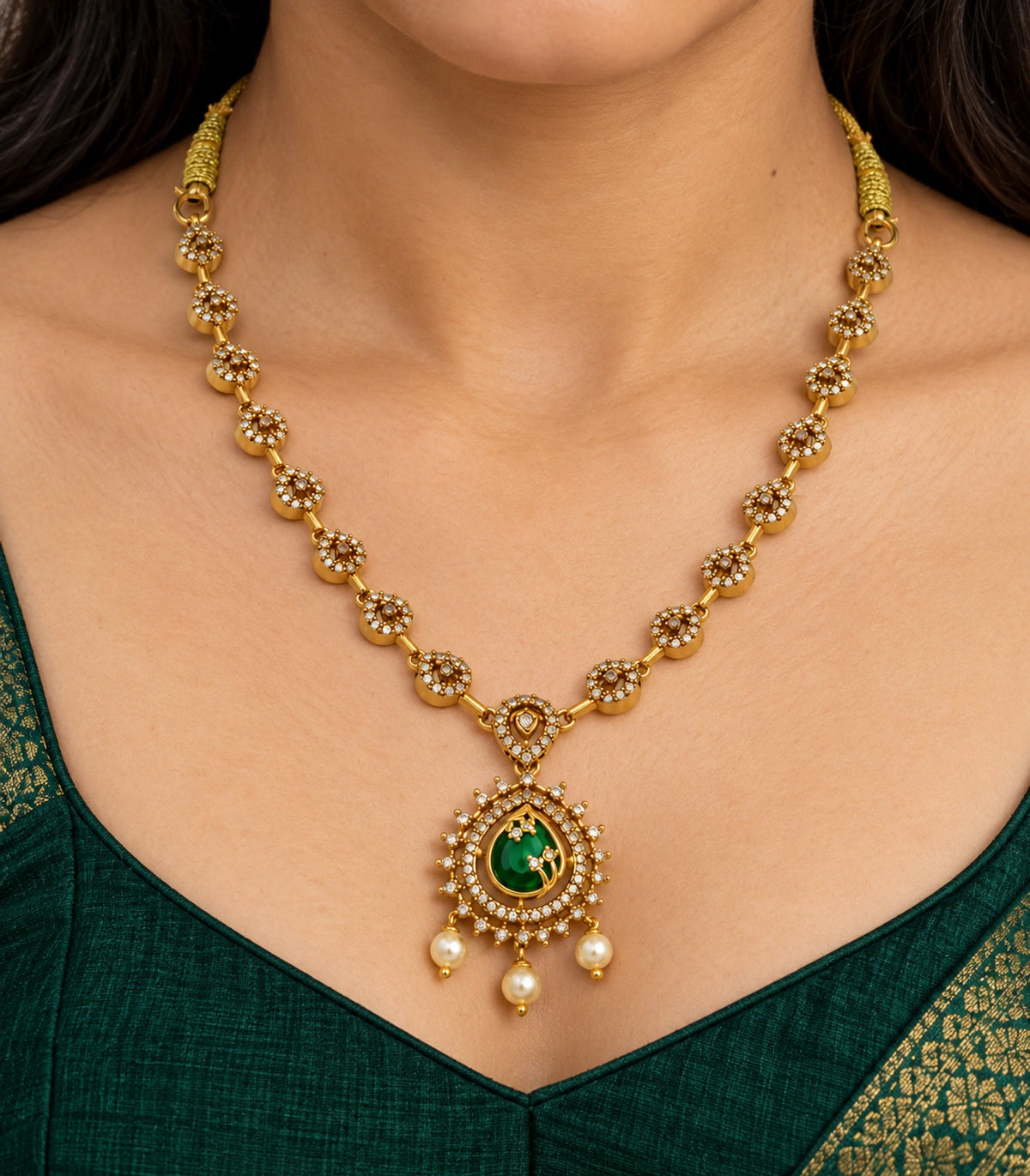 Close view of the green teardrop pendant, sixteen decorative links and three pearl-style drops