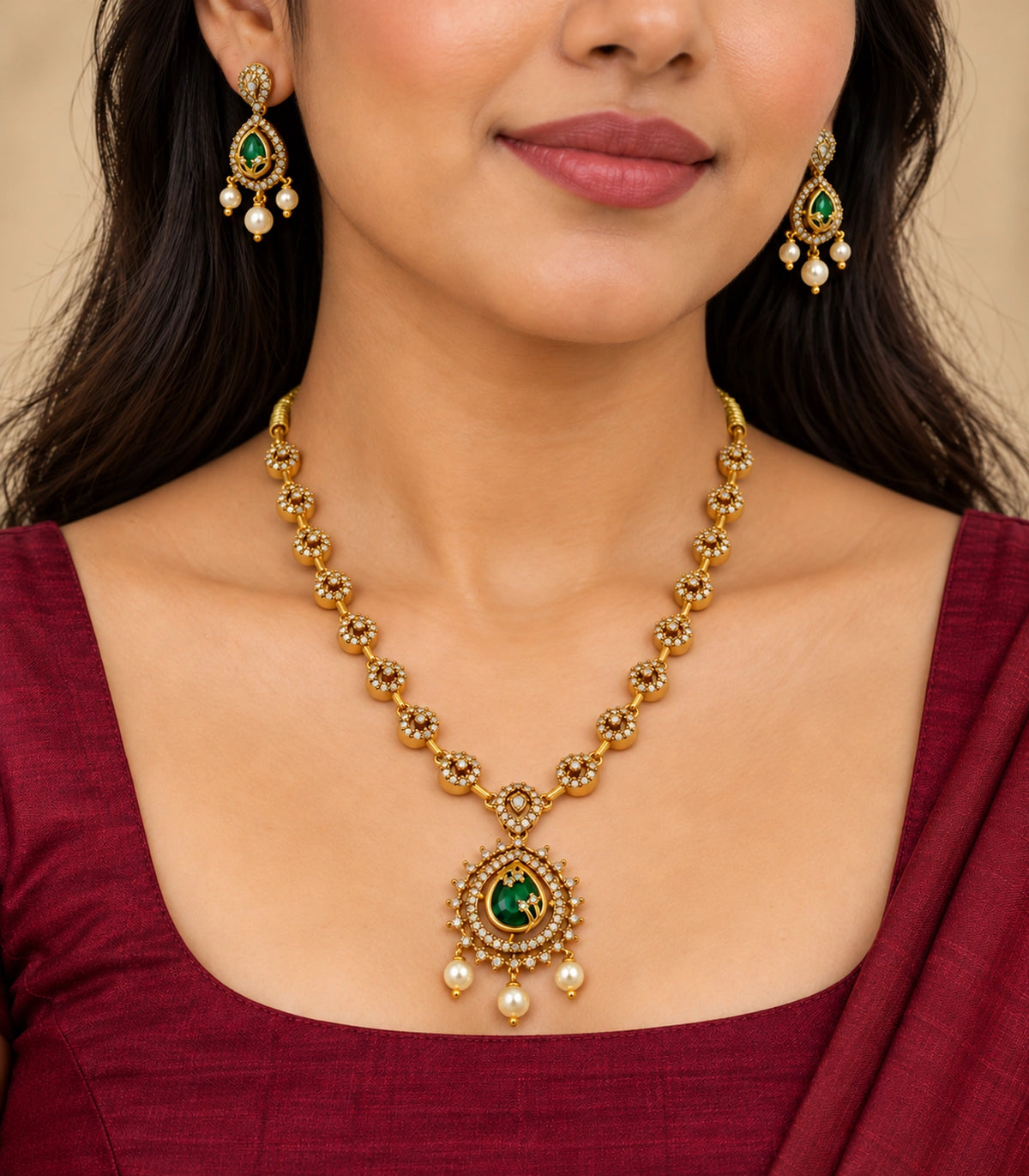 Matching green teardrop necklace and earring set worn with a burgundy blouse