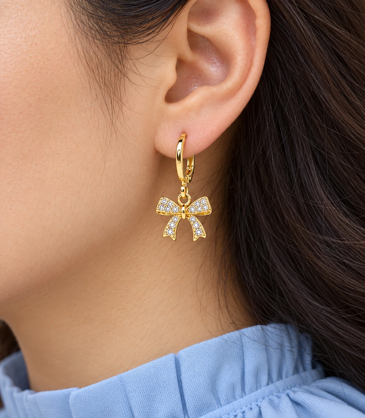 Crystal-covered ribbon bow hoop from the gold tone three-pair set, shown close up.