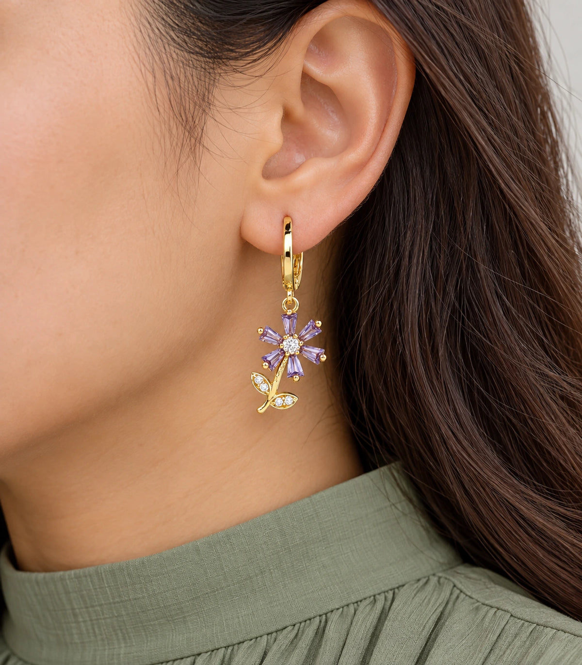 Purple six-petal flower hoop earring with clear centre and crystal-detailed leaves, worn closeup