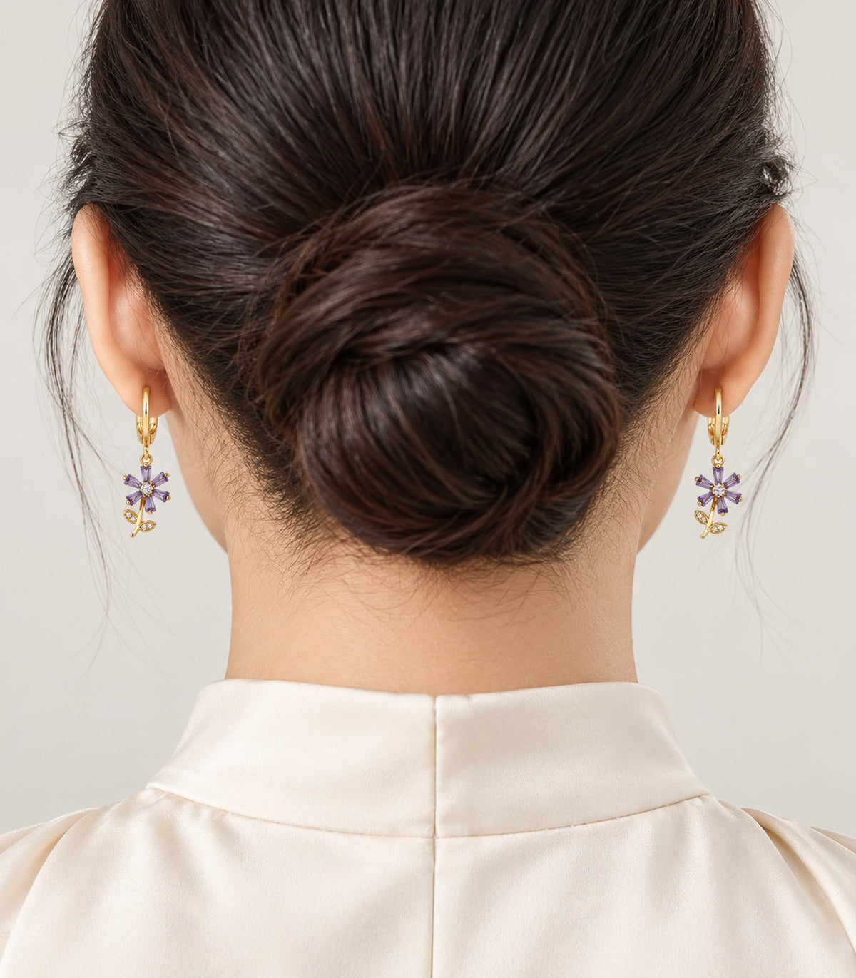 Selected pair from the gold-tone ball, crystal and purple flower hoop earring set, worn view