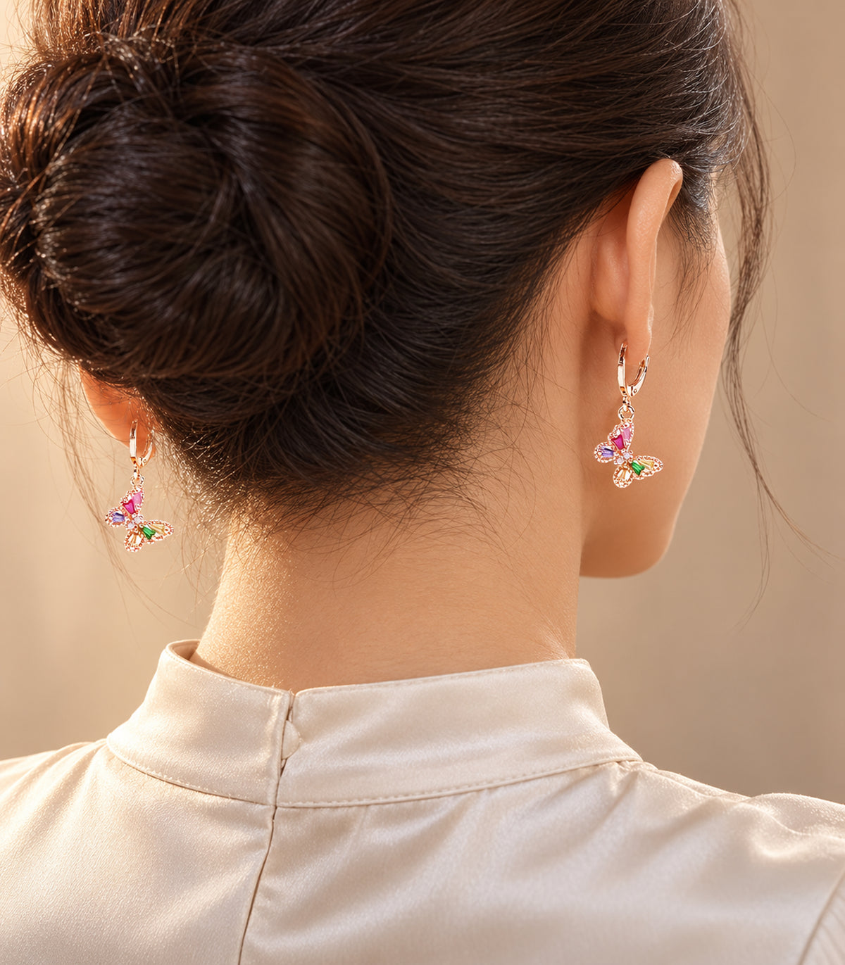 Editorial worn view of rose gold tone hoop earrings from the three-pair set