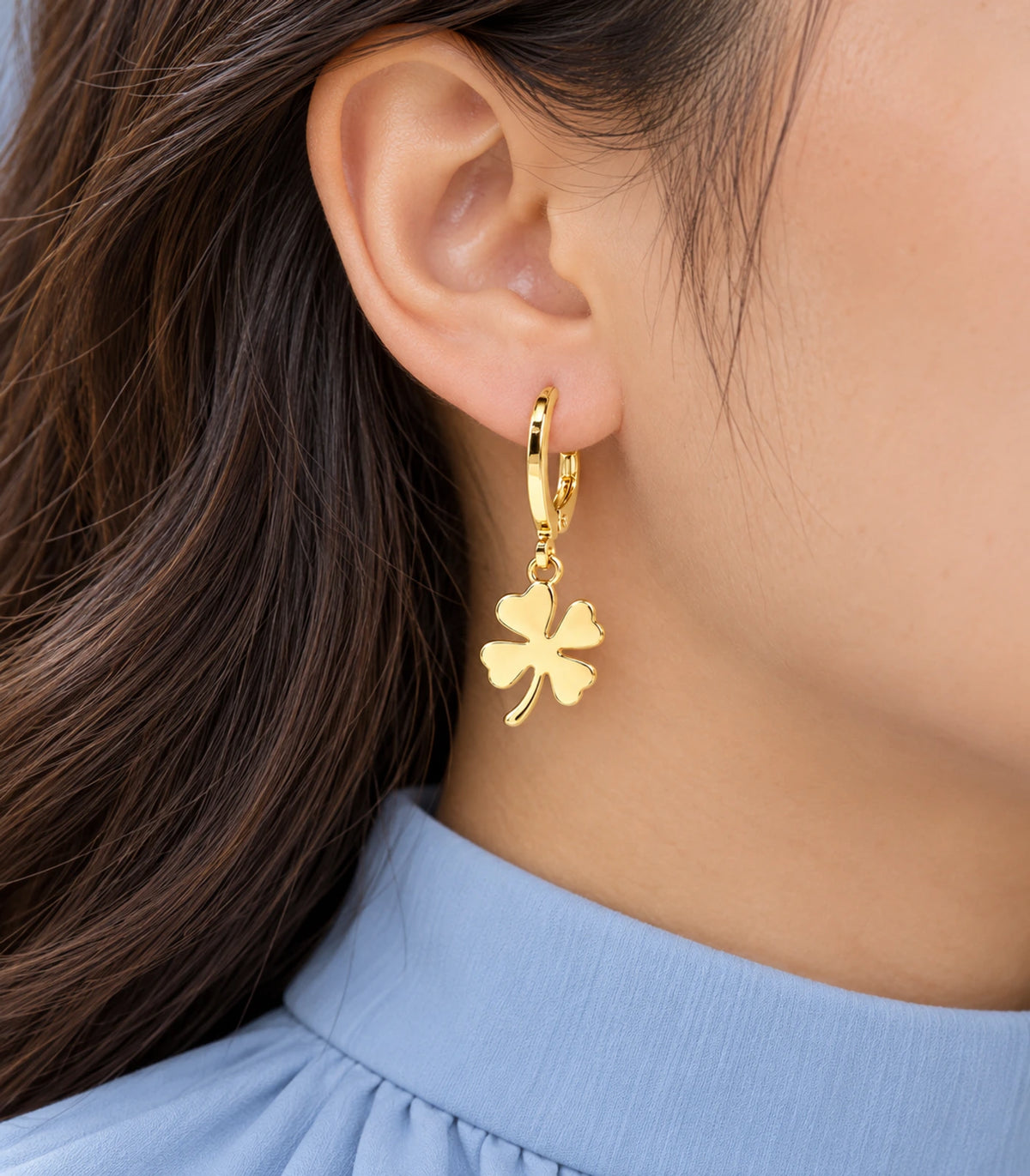 Gold-tone four-leaf clover hoop earring closeup