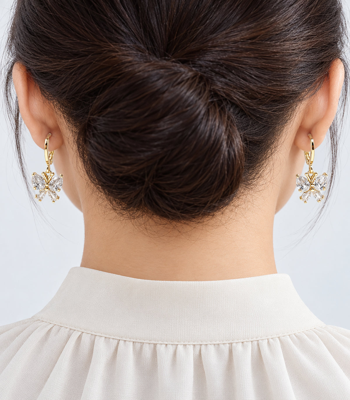 Gold-tone crystal hoop earrings worn from the three-pair set