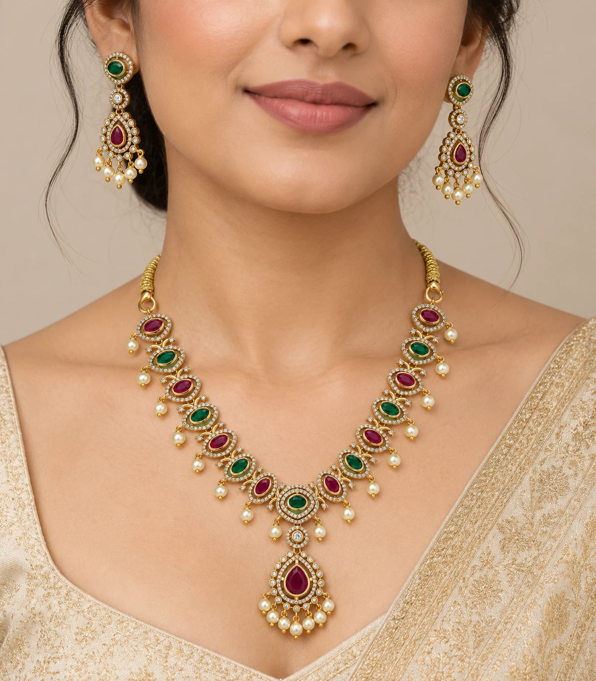 Gold-tone magenta and green oval-link necklace set with matching earrings worn with an ivory outfit