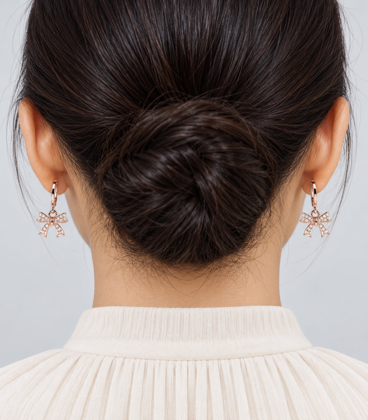 Rose gold tone hoop earrings worn to show one included pair from the three-pair set