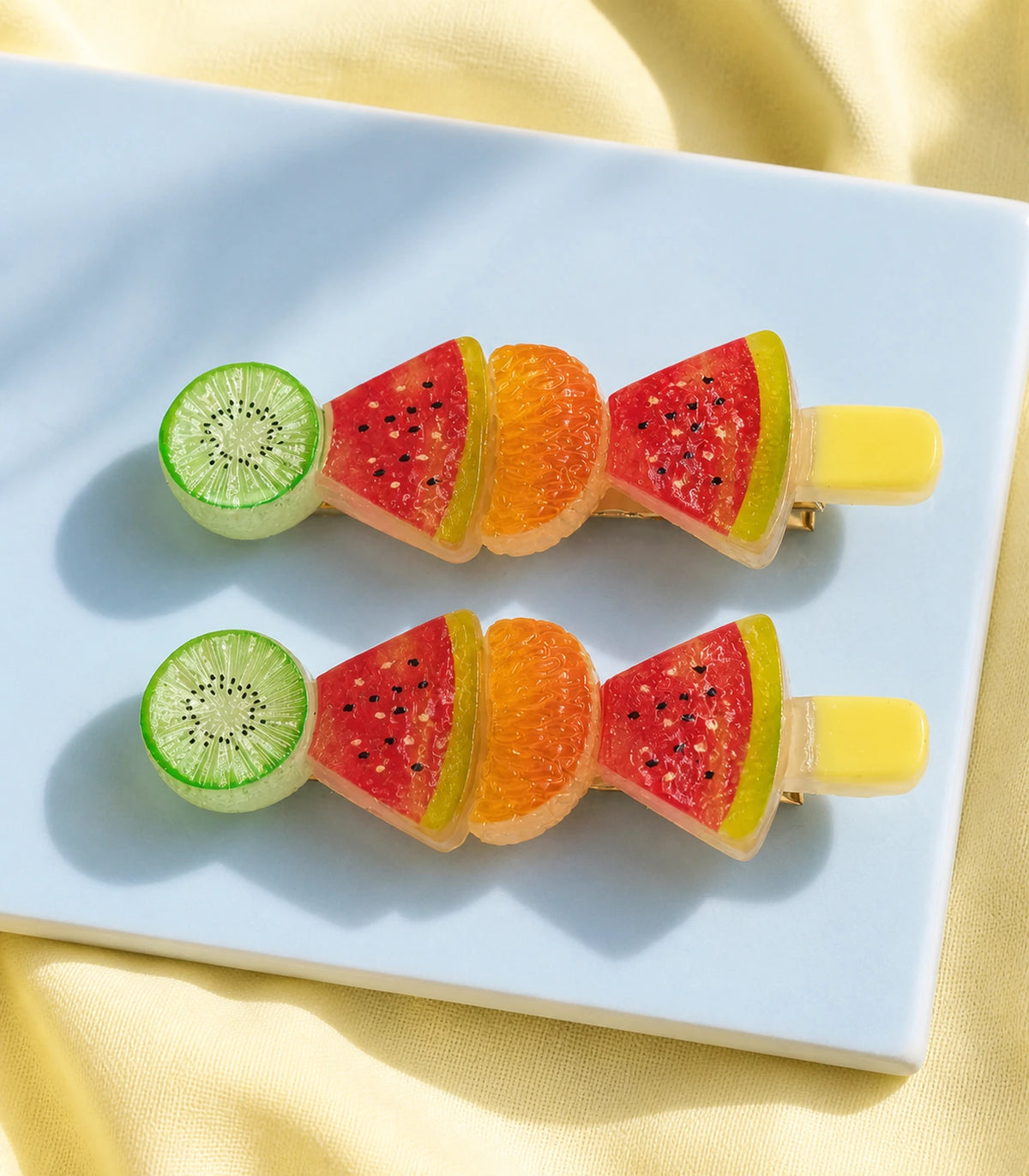 Editorial flat lay of the Kiwi Watermelon Orange Fruit Barrette Pair