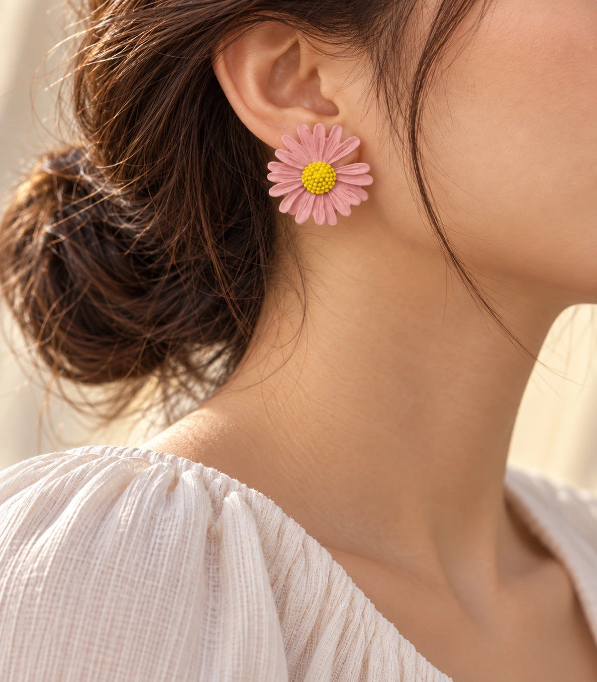 JIMIKI Light Pink yellow centre daisy stud earrings, earring worn in a warm editorial setting #color_light pink