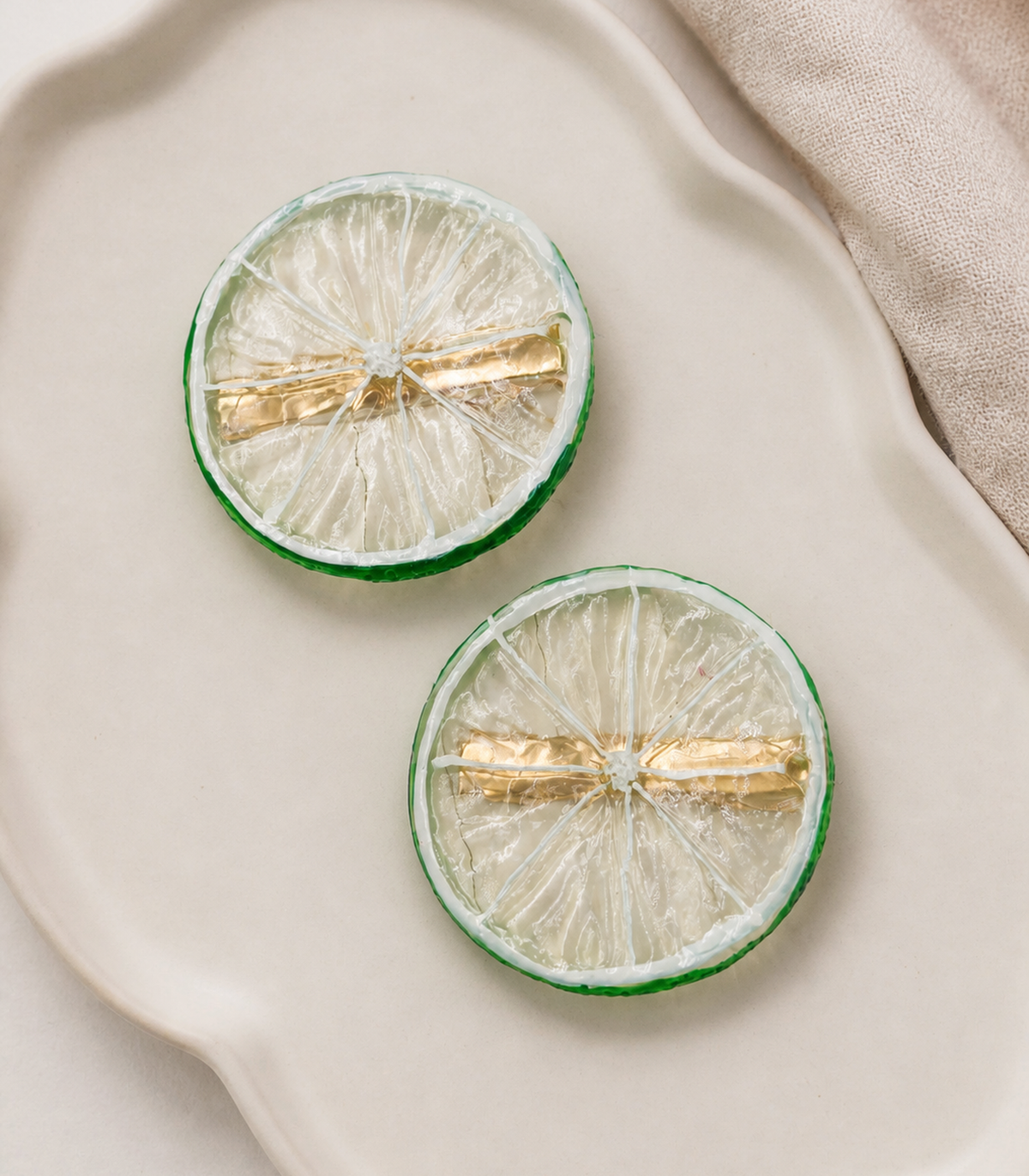 JIMIKI Translucent Lime Slice Barrette Pair in Clear / Green, editorial flat lay