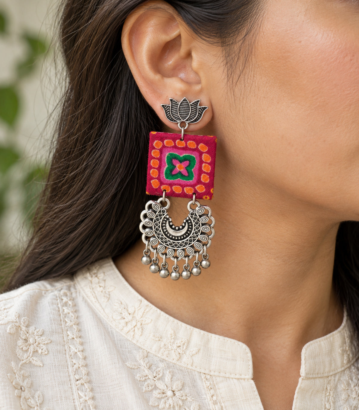 Magenta and green lotus crescent fabric earrings - closeup view