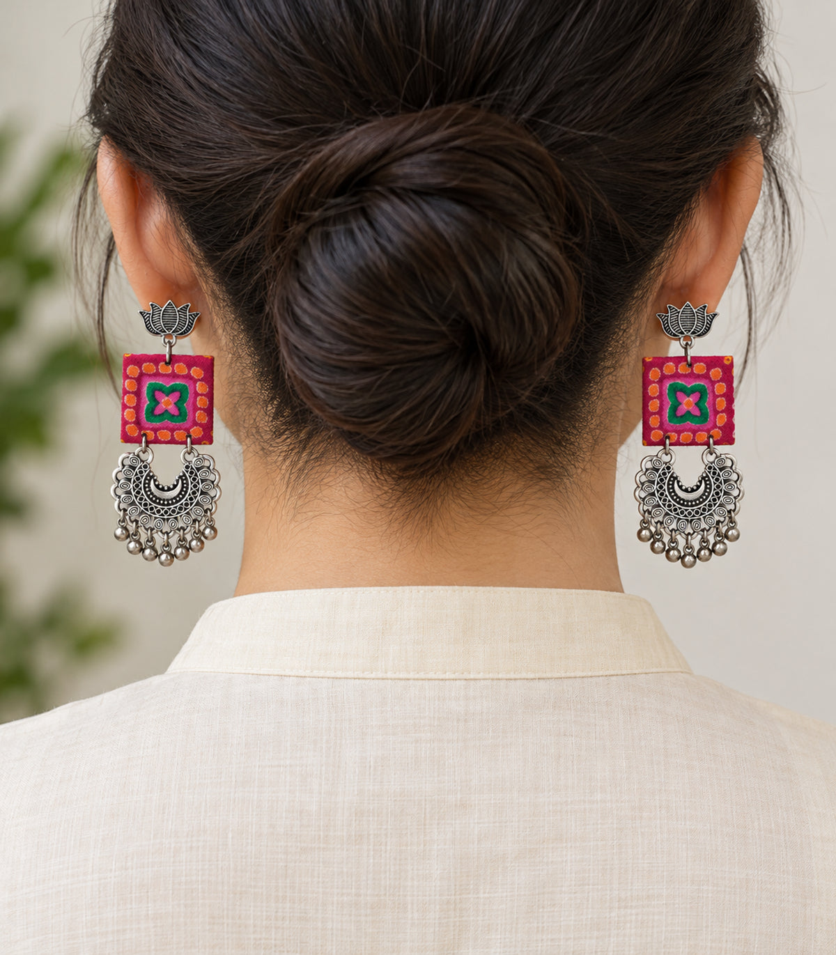 Magenta and green lotus crescent fabric earrings - model view