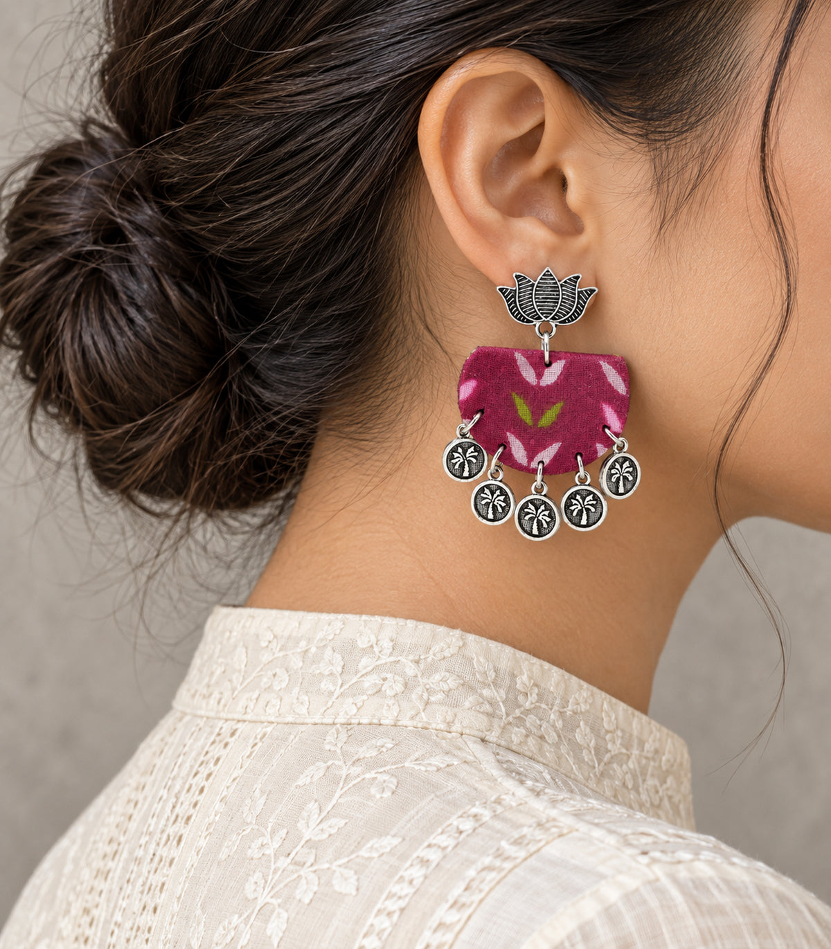 Magenta leaf fabric lotus coin earrings — editorial-model single earring detail