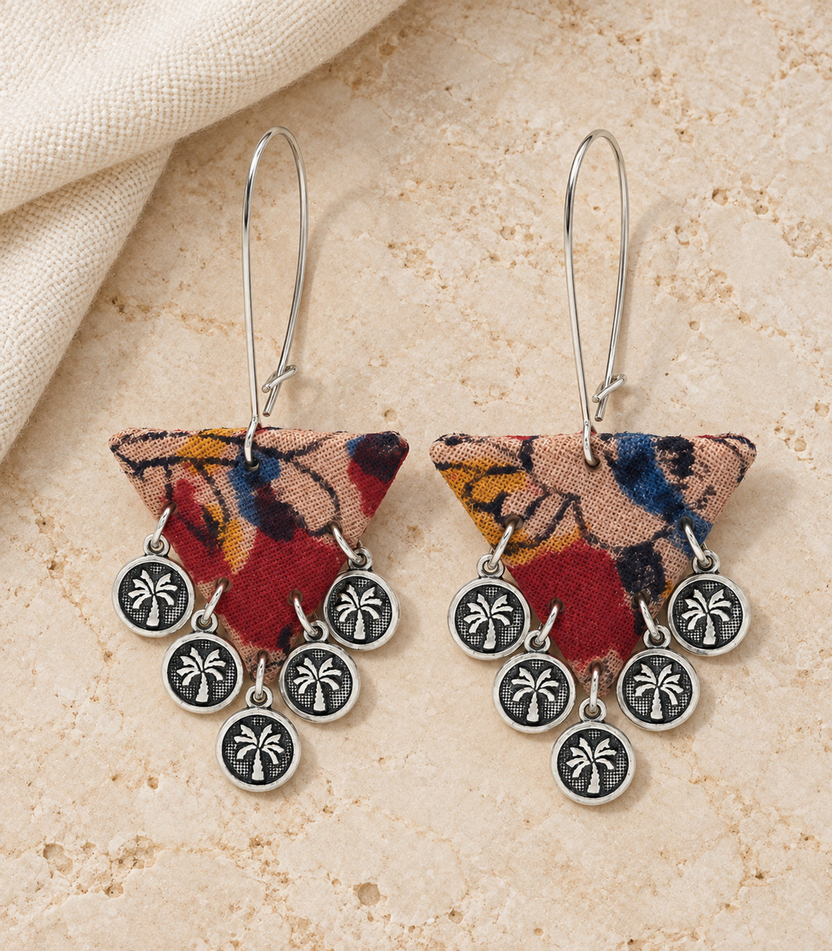 Multicolour triangle fabric coin earrings — complete pair in an editorial flatlay