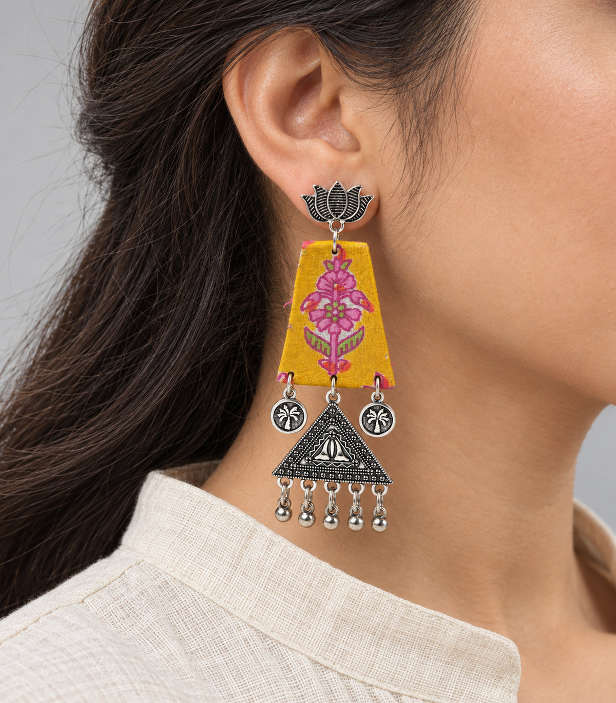 Mustard floral fabric lotus triangle earrings - closeup worn view of one earring
