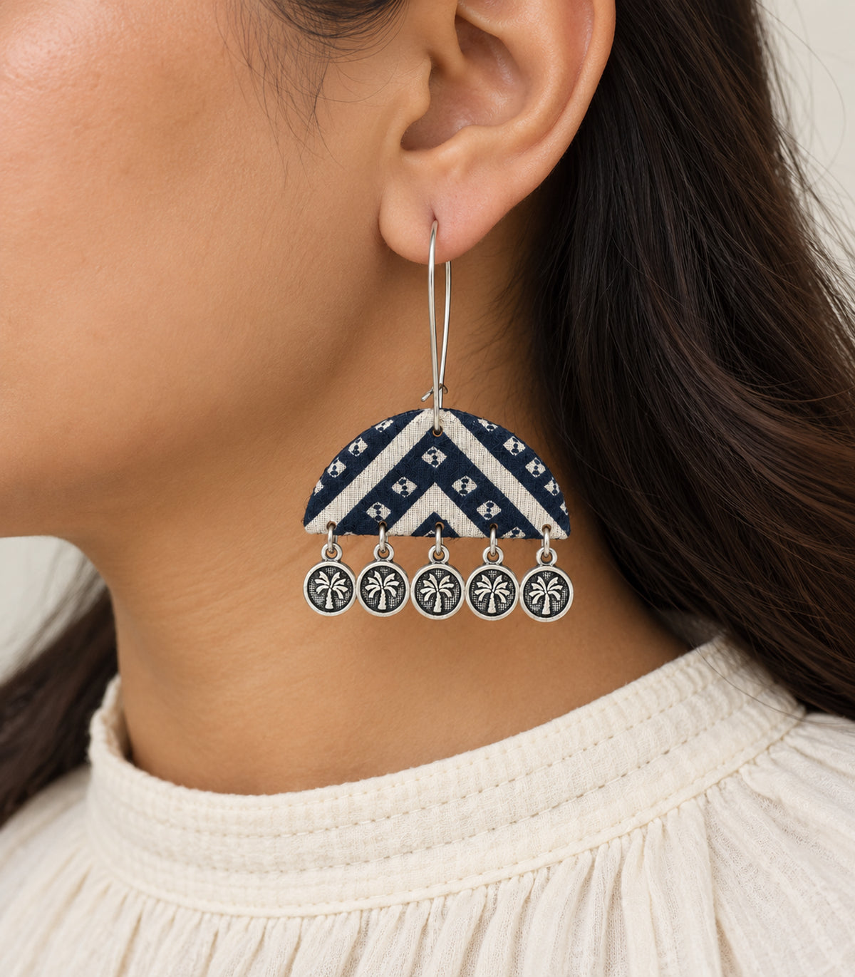 Close view of navy and ivory chevron flower coin earring and silver-tone drops