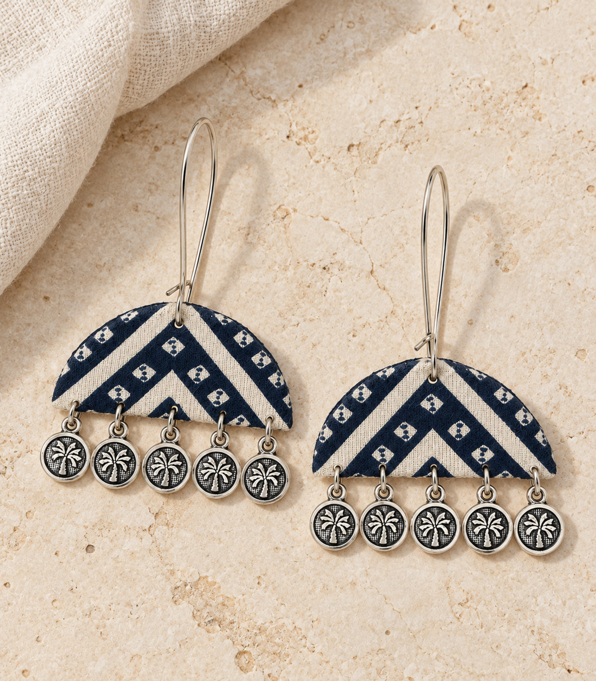 Matching pair of navy and ivory chevron flower coin earrings in styled flatlay