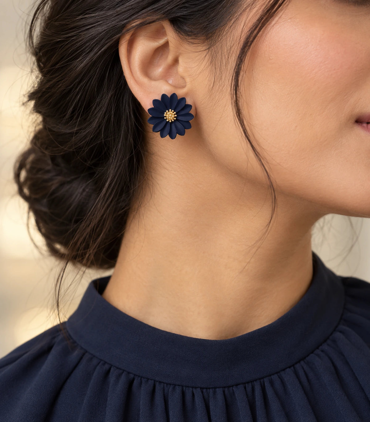 JIMIKI Navy layered starburst daisy stud earrings, editorial portrait of the daisy stud worn at the ear #color_navy