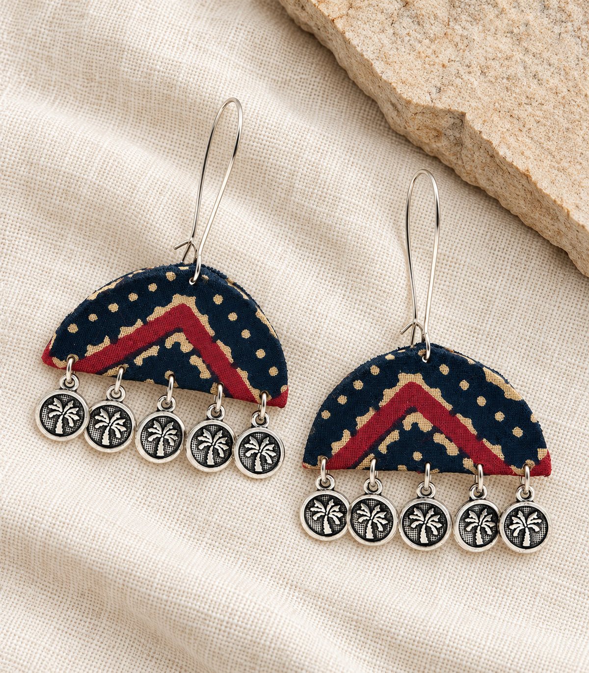 Complete pair of navy and maroon chevron fabric coin drop earrings on ivory linen