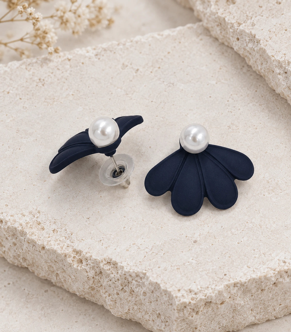 JIMIKI Navy pearl fan petal stud earrings, pair in an editorial flat lay #color_navy