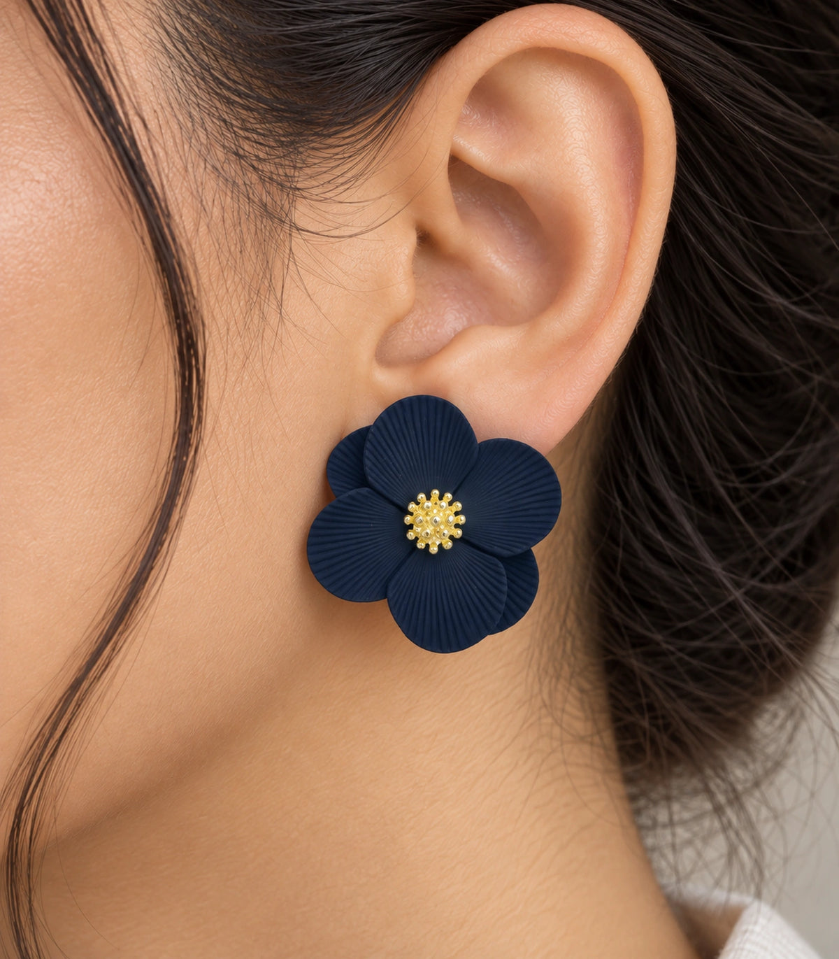 JIMIKI Navy ribbed flower stud earrings, worn closeup of ribbed petals and gold-tone centre #color_navy