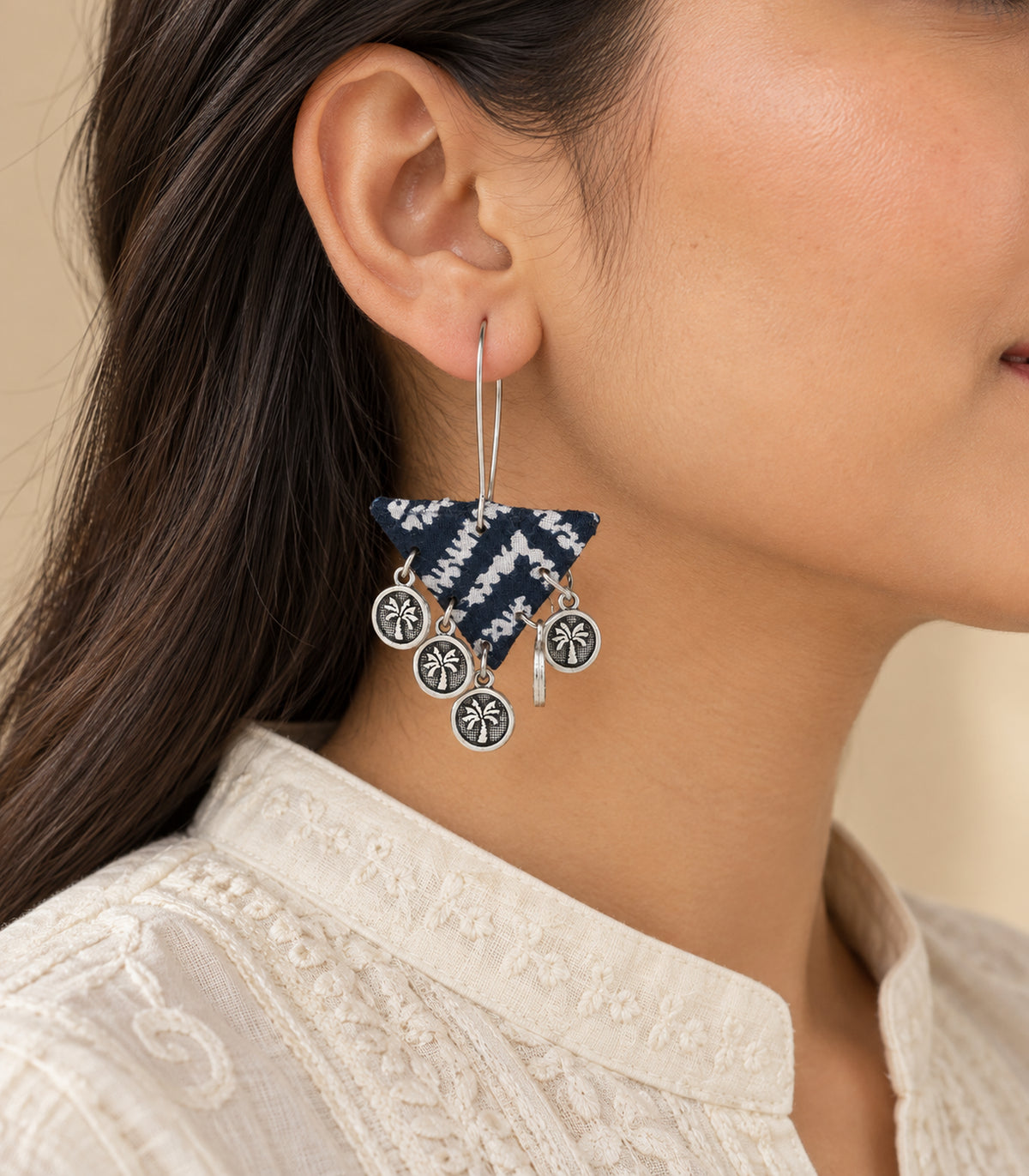 Navy and white triangle fabric coin earring worn in side view