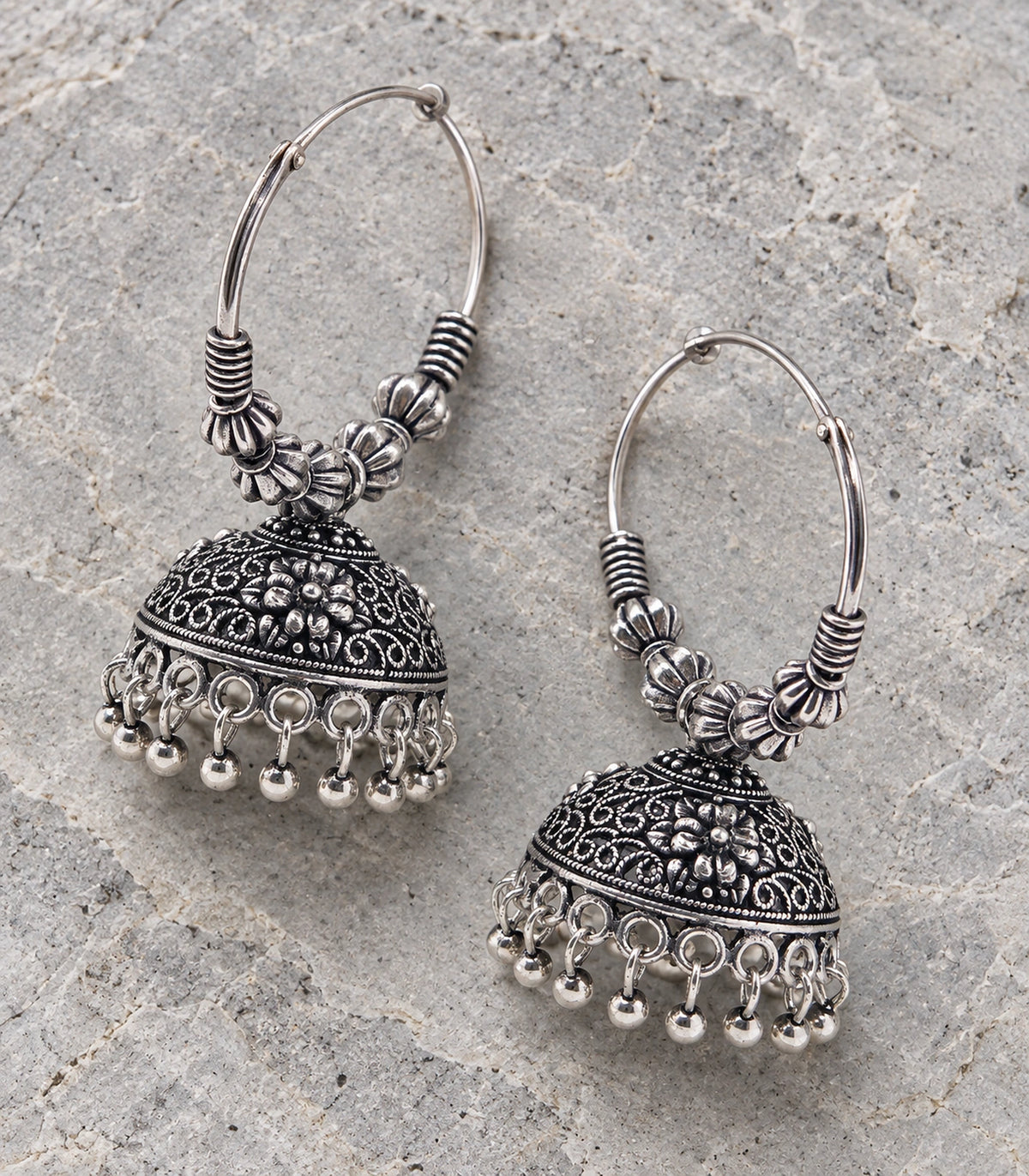 JIMIKI Beaded Hoop Floral Jhumka Earrings - Oxidized Silver pair in a styled flatlay #color_oxidized-silver