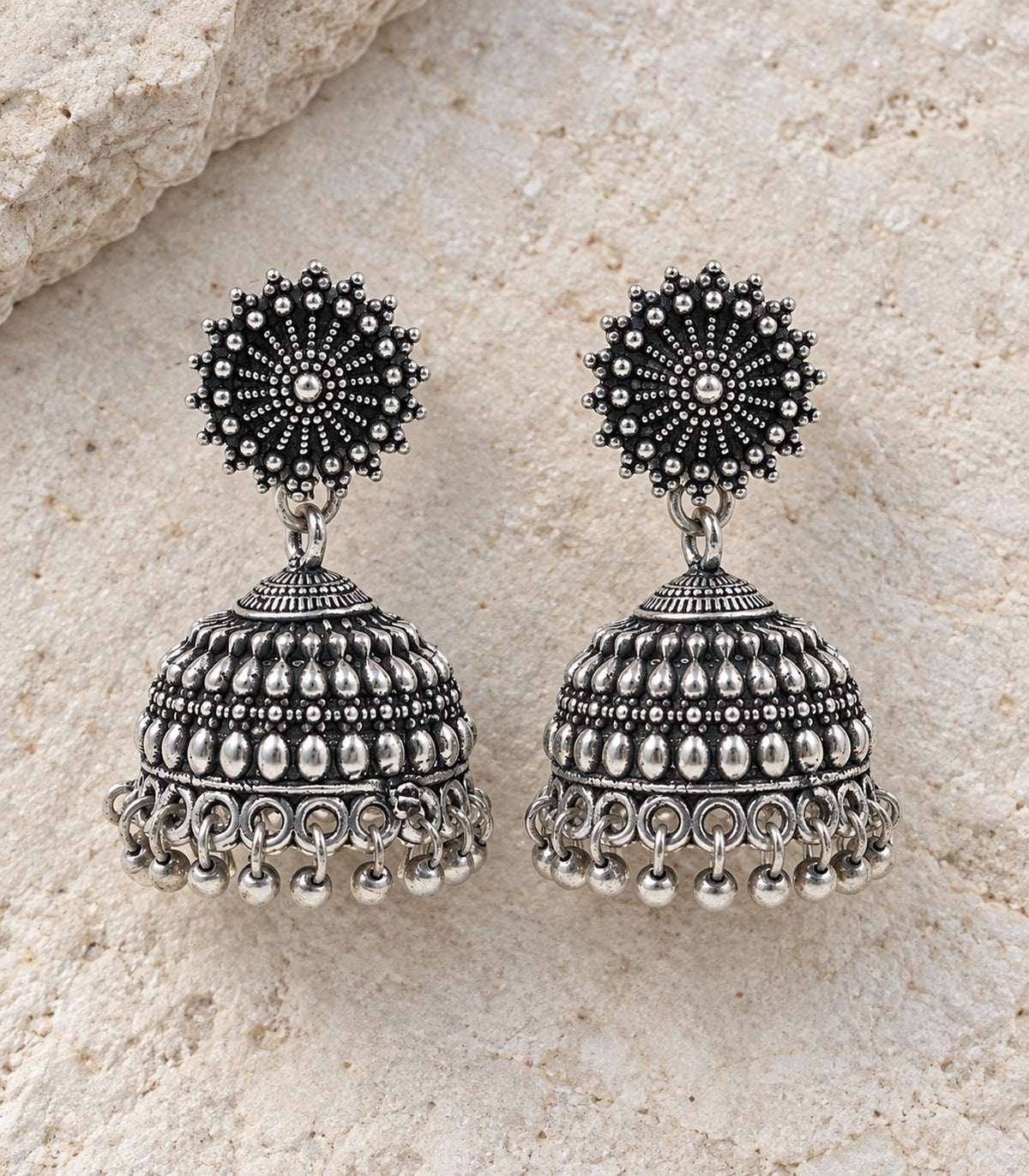 JIMIKI Oxidized Silver Beaded Sunburst Jhumka Earrings - styled flatlay of the matching earrings #color_oxidized-silver