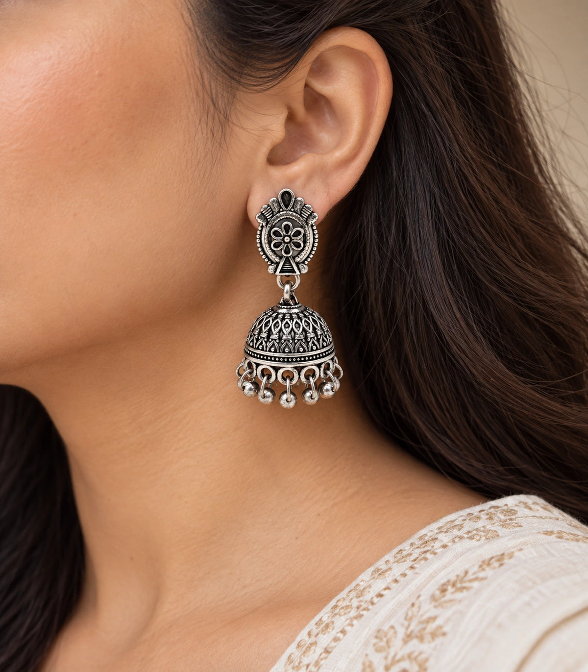 JIMIKI Oxidized Silver Oval Floral Jhumka Earrings - Earring worn with a cream outfit #color_oxidized-silver