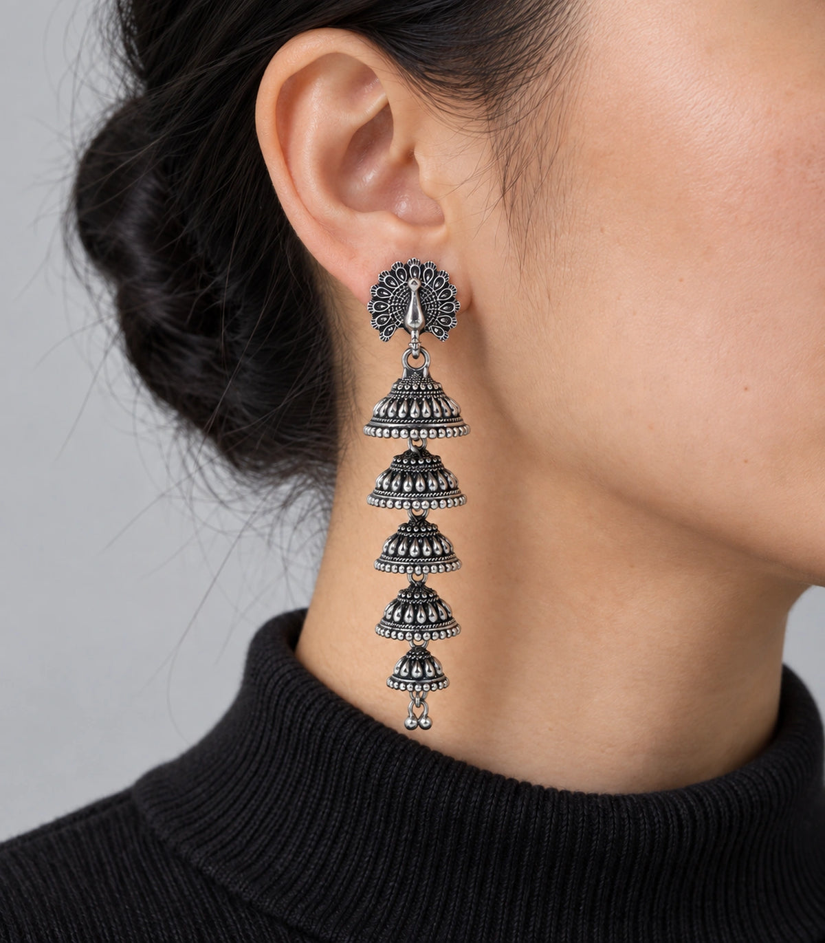 JIMIKI Peacock Five Tier Jhumka Earrings in Oxidized Silver - worn styling view #color_oxidized-silver