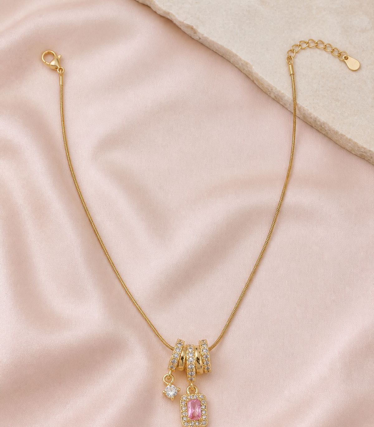 Pink Baguette Charm Necklace in an editorial flat lay