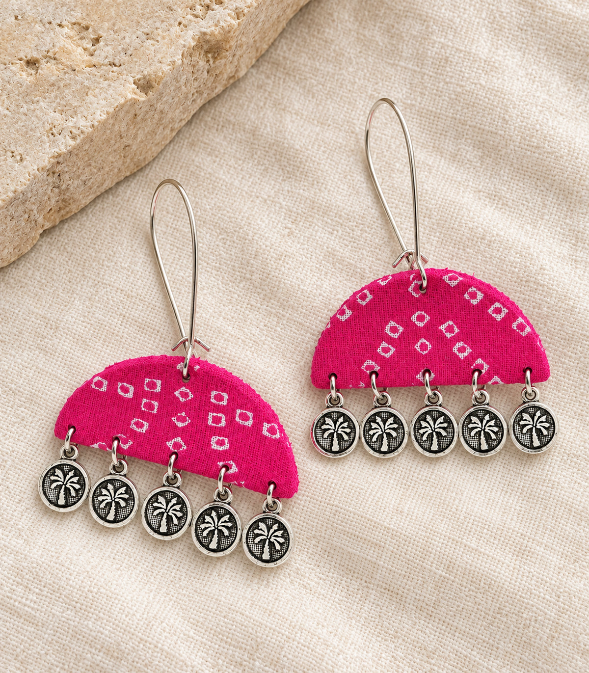 Complete pink semicircle five-coin earring pair on ivory fabric